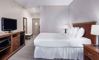 a modern hotel room with a large bed , white bedding , and a tv on a wooden dresser at Country Inn & Suites by Radisson, Toledo, Oh
