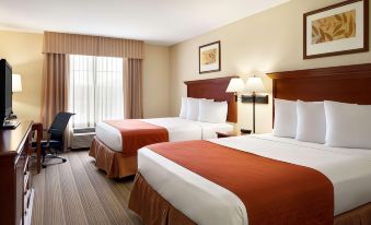 a hotel room with two beds , each made up with white sheets and red blankets , next to a window with blinds and curtains at Country Inn & Suites by Radisson, Baltimore North/White Marsh