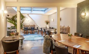 a modern restaurant with a dining table , chairs , and a large skylight above the bar at Hotel the Shepherd