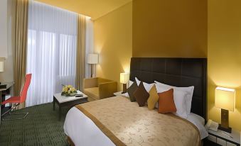 a large bed with a brown headboard and white sheets is in a hotel room at Golden Flower by Kagum Hotels