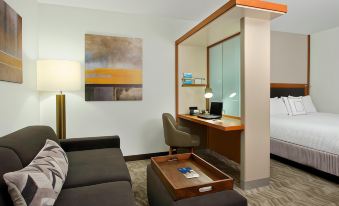 a hotel room with a bed , a chair , and a desk in the corner at SpringHill Suites Madera
