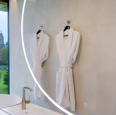 a bathroom with two white bathrobes hanging on a rack , next to a sink and a window at Oval Hotel at Adelaide Oval, an EVT hotel