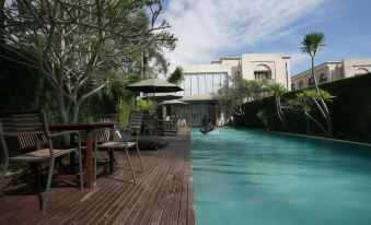 a beautiful swimming pool area with umbrellas , lounge chairs , and a wooden deck surrounding the pool at The Pade Hotel