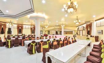 a large banquet hall with multiple tables and chairs arranged for a formal event , possibly a wedding reception at Lampam Resort