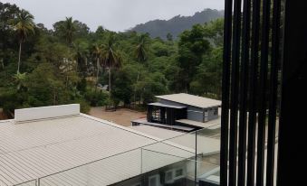 a view of a building and its surrounding area , with trees in the foreground and mountains in the background at Casa Hill Resort