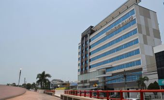 a modern building with blue and white colors , surrounded by palm trees and a red bench at Chaisaeng Palace Hotel