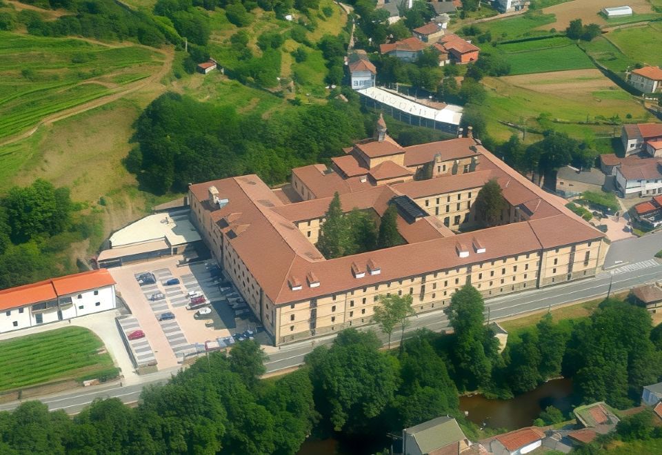 an aerial view of a large building with a parking lot in front of it at Parador Monasterio de Corias