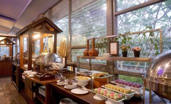 a buffet table filled with a variety of food items , including fruits , pastries , and desserts at Forbis Hotel