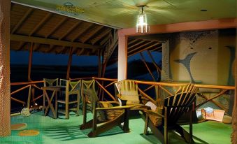 a wooden deck with chairs and a hanging light , inviting people to relax and enjoy the view at Altos de Cano Hondo