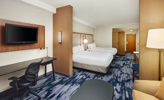 a hotel room with two beds , a desk , and a tv , all neatly arranged in the space at Fairfield Inn & Suites Worcester Auburn