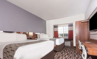 a hotel room with two beds , one on the left side of the room and the other on the right at Microtel Inn & Suites by Wyndham Sweetwater