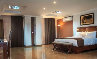 a modern bedroom with white walls , brown curtains , and a bed in the center of the room at Residence Maryka II