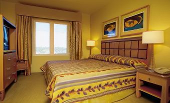 a hotel room with a large bed , a window , and a painting on the wall at Aquarius Vacation Club at Dorado del Mar