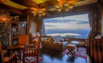 a cozy living room with wooden furniture , including a couch , chairs , and a dining table at Ngorongoro Serena Safari Lodge