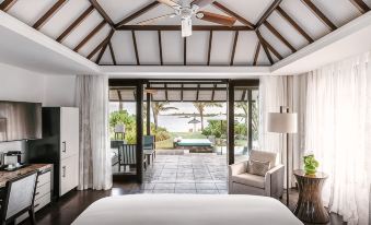 a luxurious bedroom with a large bed and a view of the ocean through the doorway at Four Seasons Resort Mauritius at Anahita