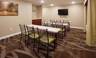 a conference room with chairs arranged in a semicircle around a table and a television mounted on the wall at Comfort Inn & Suites