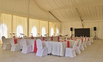 a large white tent with tables and chairs set up for an event , possibly a wedding or conference at Sweetwaters Serena Camp