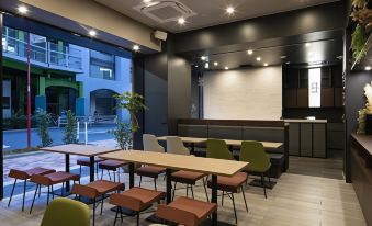 The restaurant features an open concept dining room with tables, chairs, and a counter at Grids Tokyo Ueno Hotel&Hostel