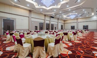 a large banquet hall with multiple tables and chairs arranged for a formal event , possibly a wedding reception at Raia Hotel & Convention Centre Alor Setar