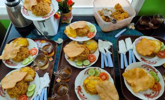 a dining table filled with a variety of food items , including sandwiches , fried chicken , and other dishes at Bakom Inn Syariah