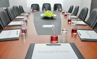 a conference table set up for a meeting , with several chairs arranged around it and a laptop on the table at Indaba Lodge Gaborone