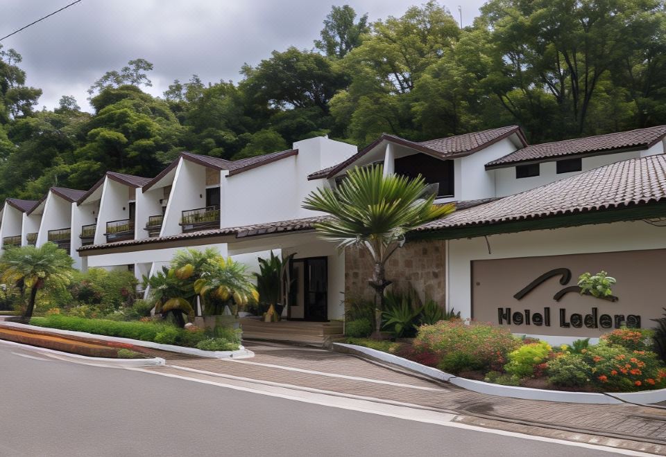 "a large white house with a sign that reads "" hotel rio de janeiro "" is surrounded by greenery and flowers" at Hotel Ladera