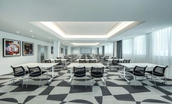 a large , empty conference room with black and white checkered floor and multiple tables set for meetings at Vibe Hotel Sydney