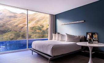a large bed with white linens is situated in a room with blue walls and a window at Marriott Maracay Golf Resort