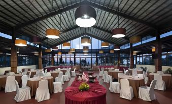 a large , well - lit dining room with multiple tables and chairs arranged for a formal event at Alfa Resort Hotel and Conference