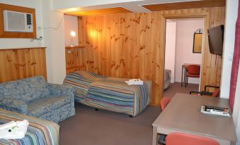 a room with a wooden wall and ceiling , featuring a couch and table in the center at Barossa Gateway Motel