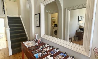a foyer with a staircase leading to the second floor , and a large mirror hanging on the wall at Athelstane House