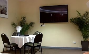 a dining room with a table , chairs , and a flat - screen tv mounted on the wall at The Lighthouse Hotel