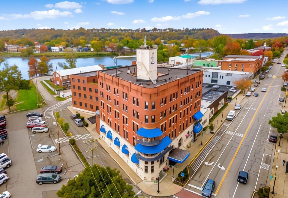 a red brick building with a blue roof and white columns is situated on a street corner at Lafayette Hotel Marietta