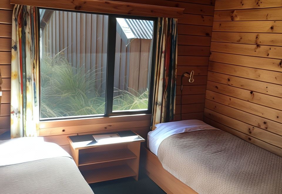 a room with two twin beds , one on the left side and the other on the right side of the room at Alpine Lodge