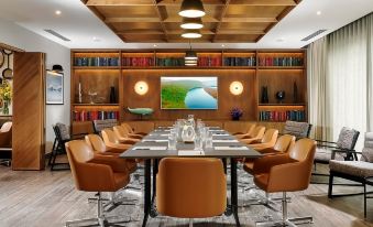 a long dining table with chairs and a television mounted on the wall in a room at Shannon Springs Hotel