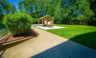 a wooden gazebo is situated in a park with trees and a walkway leading to it at Country Inn & Suites by Radisson, Burlington (Elon), NC