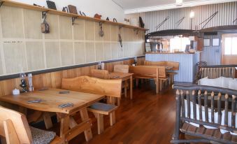 a restaurant with wooden tables and chairs , a bar , and various items on the shelves at Mountain View Country Inn