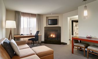 a modern living room with a couch , coffee table , and fireplace , as well as a television mounted on the wall at Residence Inn Greenville