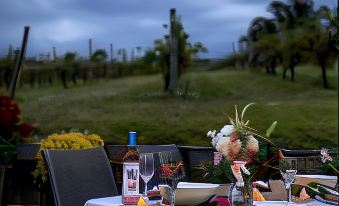 a table set for a meal with wine glasses and a bottle of wine in the foreground at De'Vine Escape