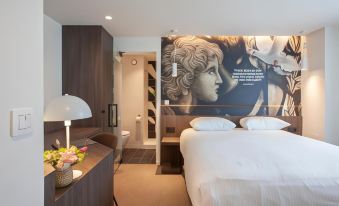 a modern hotel room with a large bed , desk , and a mural on the wall at Hotel the Shepherd