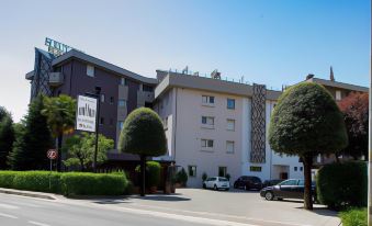 "a large building with a sign that says "" conical office "" is surrounded by trees and cars" at Hotel Park