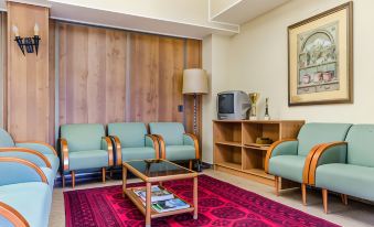 a living room with two couches , a coffee table , and a television mounted on the wall at Hotel Mora