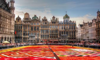 a large , red and yellow flower arrangement is placed in the middle of a city square at Ibis Brussels Airport