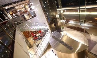 a modern building with a glass staircase and a unique design of glass railings , reflecting the night sky at Novotel Canberra