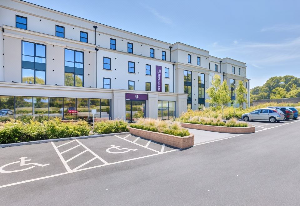a modern hotel building with multiple windows , a large parking lot , and a clear blue sky at Premier Inn Bangor (Northern Ireland)