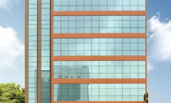 a close - up view of the side of a modern building with orange windows and a cityscape visible in the background at Hallmark Regency Hotel - Johor Bahru