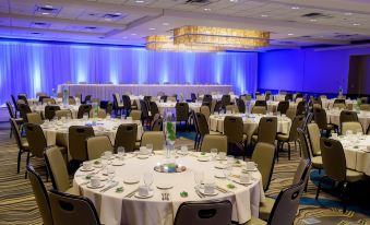 a large banquet hall filled with round tables and chairs , ready for a formal event at Kahler Grand Hotel