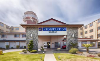 "a modern building with a sign that reads "" registration name "" and a lighthouse in the background" at Lighthouse Suites Inn