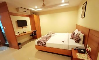 a hotel room with a large bed , a desk , and a tv . the room is clean and well - organized at Landmark Hotel