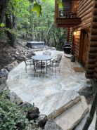 Cozy log cabin secluded in a mountain forest with hot tub, sauna, private patio.